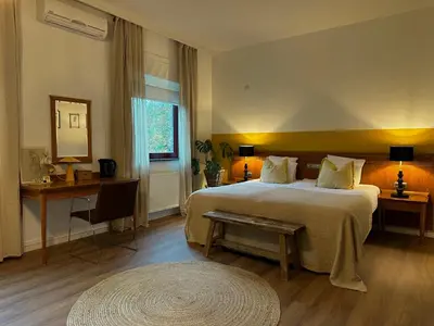 a bedroom with a bed and a table and a mirror at Guesthouse De Wissen in Dilsen-Stokkem