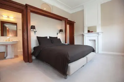 a bedroom with a large bed and a sink at Le Dragon Limbourg - Luxurious & Cozy Holiday Home in Limbourg