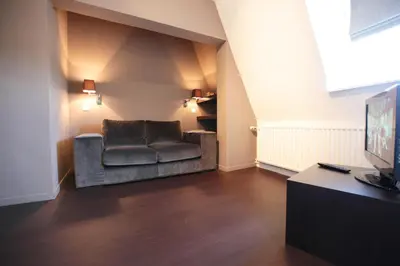 a living room with a couch and a television at Le Dragon Limbourg - Luxurious & Cozy Holiday Home in Limbourg