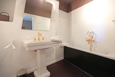a white bathroom with a sink and a bath tub at Le Dragon Limbourg - Luxurious & Cozy Holiday Home in Limbourg