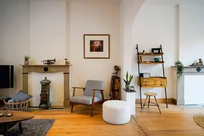 a living room with a fireplace and a chair at LOFT 44 - thuis in Hasselt in Hasselt