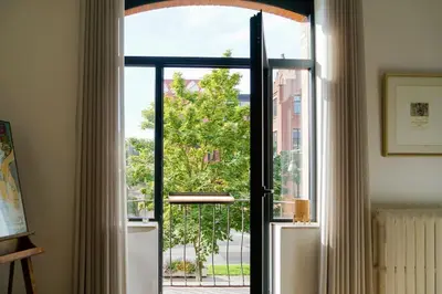 an open glass door with a view of a tree at LOFT 44 - thuis in Hasselt in Hasselt