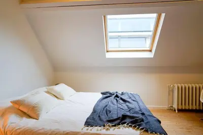 a bed in a room with a window at LOFT 44 - thuis in Hasselt in Hasselt