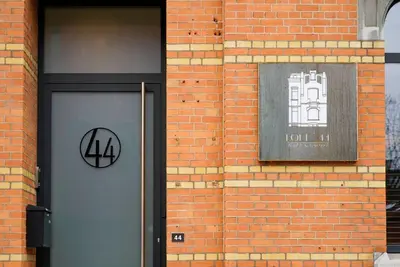 a brick building with a door with a sign on it at LOFT 44 - thuis in Hasselt in Hasselt