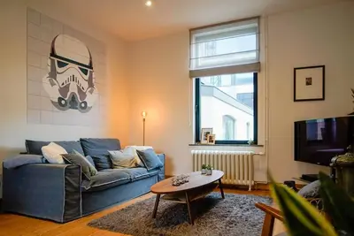 a living room with a blue couch and a table at LOFT 44 - thuis in Hasselt in Hasselt