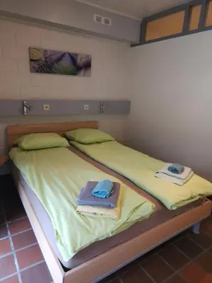 a bedroom with a bed with towels on it at Bos-Chalet bij Wijers Wandelroutes, Rust & Gezinsplezier Fijnspar 6 Hengelhoef in Houthalen-Helchteren