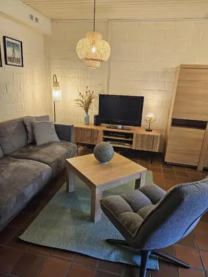a living room with a couch and a tv at Bos-Chalet bij Wijers Wandelroutes, Rust & Gezinsplezier Fijnspar 6 Hengelhoef in Houthalen-Helchteren