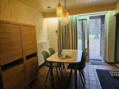 a dining room with a table and chairs at Bos-Chalet bij Wijers Wandelroutes, Rust & Gezinsplezier Fijnspar 6 Hengelhoef in Houthalen-Helchteren