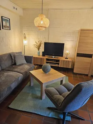 a living room with a couch and a tv at Bos-Chalet bij Wijers Wandelroutes, Rust & Gezinsplezier Fijnspar 6 Hengelhoef in Houthalen-Helchteren