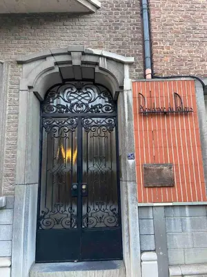 a black door on a brick building at Bel appartement spacieux Verviers in Verviers
