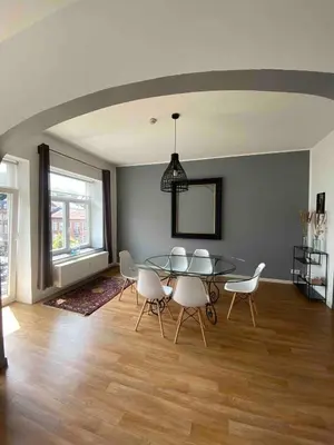 a dining room with a glass table and chairs at Bel appartement spacieux Verviers in Verviers