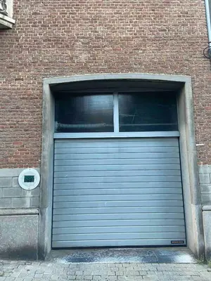 a garage door with a window in a brick building at Bel appartement spacieux Verviers in Verviers