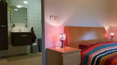 a bedroom with a bed and a bathroom with a sink at Apartment Campinor in Pelt