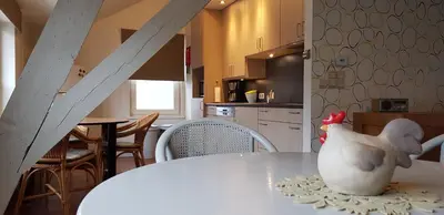 a white chicken sitting on a table in a kitchen at Apartment Campinor in Pelt