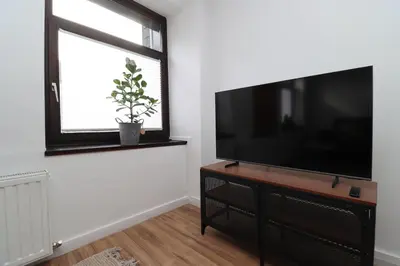 a living room with a flat screen tv and a window at Louisappart - Eupen Zentrum in Eupen