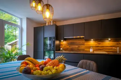 a bowl of fruit on a table in a kitchen at Gîte La Vieille Ferme Chaudfontaine et son jacuzzi in Chaudfontaine