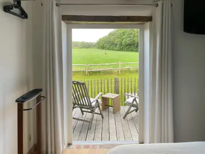 a porch with chairs and a table and a field at Vakantiehuis Eksel in Hechtel-Eksel