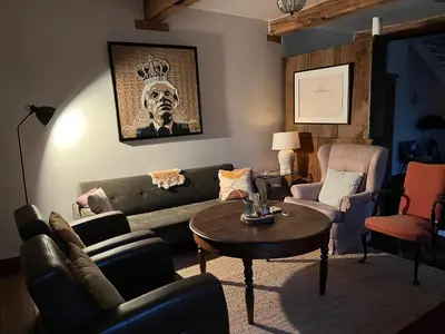 a living room with a couch and a table and chairs at Vakantiehuis Eksel in Hechtel-Eksel