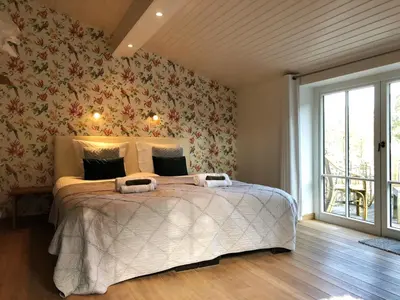 a bedroom with a large bed with floral wallpaper at Vakantiehuis Eksel in Hechtel-Eksel