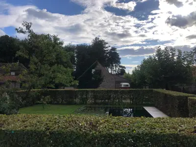 a garden with a pond in front of a house at Vakantiehuis Eksel in Hechtel-Eksel