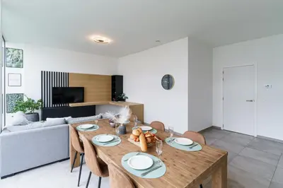 a living room with a wooden table and chairs at Nr 28 TravelHome in Heusden - Zolder