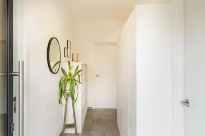 a hallway with a mirror and a plant at Nr 28 TravelHome in Heusden - Zolder