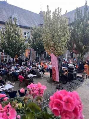 a crowd of people sitting at tables at an event at Château de Looz in Borgloon