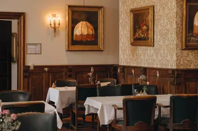 a restaurant with tables and chairs and a picture on the wall at Château de Looz in Borgloon