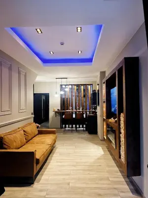 a living room with a couch and a dining room at Aslyra 