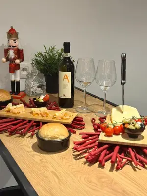 a table with a bottle of wine and food and wine glasses at LCforyou in Juprelle