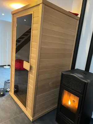a small wooden cabin with a fireplace in a room at LCforyou in Juprelle