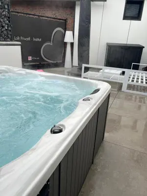 a large hot tub in a room with a tv at LCforyou in Juprelle