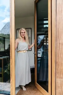 a woman is standing in front of a door at Sweet Valley View - Architectenwoning in Zutendaal