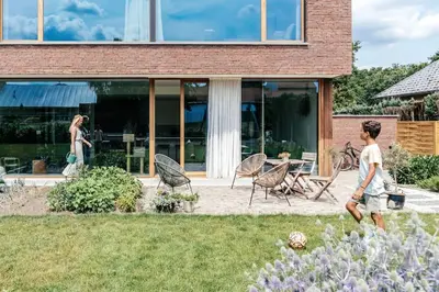 a young boy walking in the yard of a house at Sweet Valley View - Architectenwoning in Zutendaal