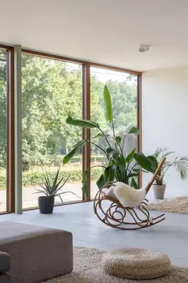 a living room with plants and a large window at Sweet Valley View - Architectenwoning in Zutendaal