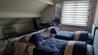 two beds in a room with a window at MARINA in Houthalen-Helchteren