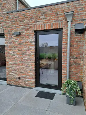 a brick wall with a sliding glass door with a patio at Hotel Apartments Belgium 5 - HAB 5 in Balen