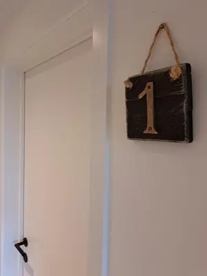a door with a number one hanging on the wall at Hotel Apartments Belgium 5 - HAB 5 in Balen