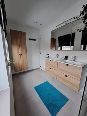 a bathroom with two sinks and a blue rug at Hotel Apartments Belgium 5 - HAB 5 in Balen
