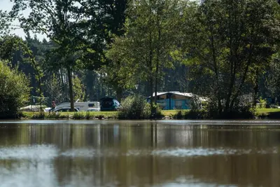 a view of a body of water with trees and cars at Jocomo Parc in Lanaken