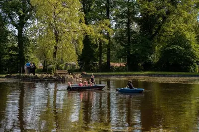 a group of people riding in boats on a lake at Jocomo Parc in Lanaken