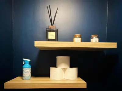 a shelf with toilet paper and a bottle on it at Suite luxueuse aux Guillemins in Liège