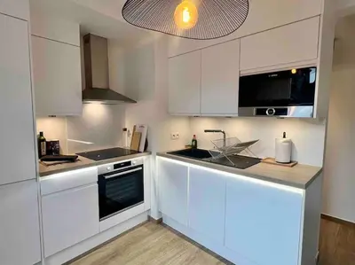 a white kitchen with white cabinets and a sink at Le contemporain - Plein centre, place du Marché in Liège