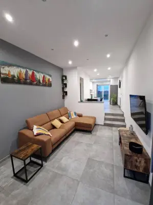 a living room with a couch and a table at charmante maison 2 chambres, entièrement rénovée in Jeuk