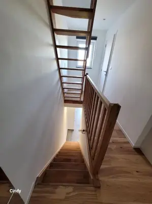 a staircase in a building with a wooden stair case at charmante maison 2 chambres, entièrement rénovée in Jeuk