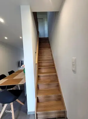 a stairway in an office with a table and a room at charmante maison 2 chambres, entièrement rénovée in Jeuk