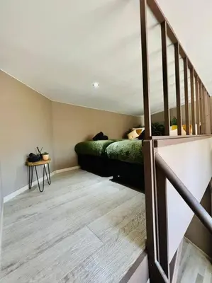 a bedroom with a green bed and a staircase at Appartement tropical in Liège
