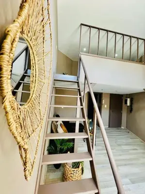 a spiral staircase in a room with a mirror at Appartement tropical in Liège
