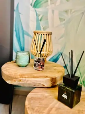 a wooden table with two cups and a vase on it at Appartement tropical in Liège