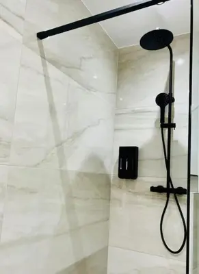 a bathroom with a shower with a glass door at Appartement tropical in Liège
